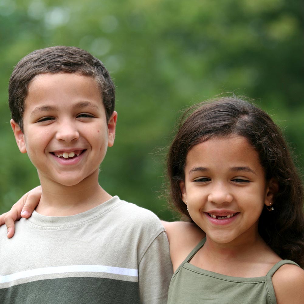 a boy and girl smiling towards the camera