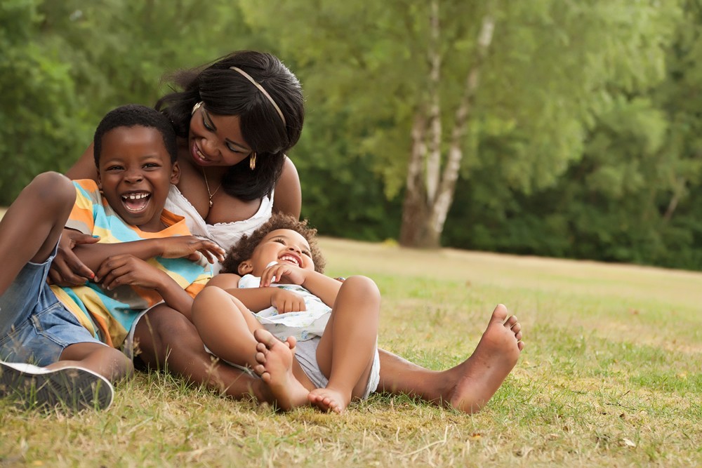 a parent with her two children playing in a park